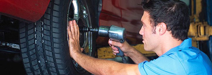 man fixing car wheel